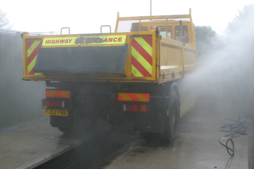 The underside of a tipper truck undergoes high-pressure automatic cleaning.