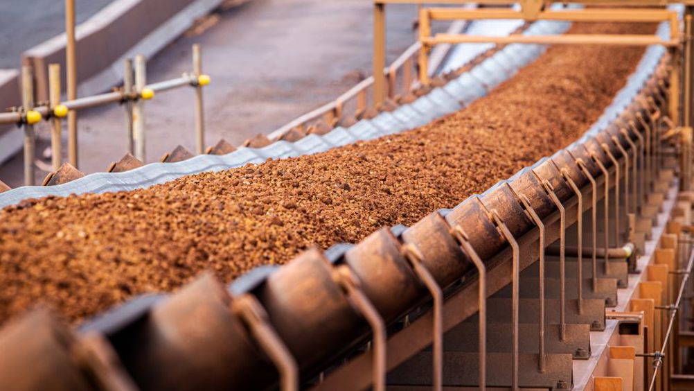 A conveyor belt moving iron ore.