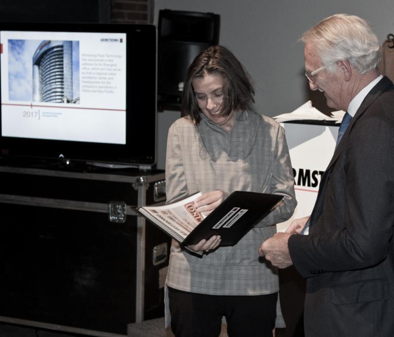 Charles Armstrong, Armstrong’s chairman, presenting the photos to Caroline Andrieux, the curator and owner of the gallery.
