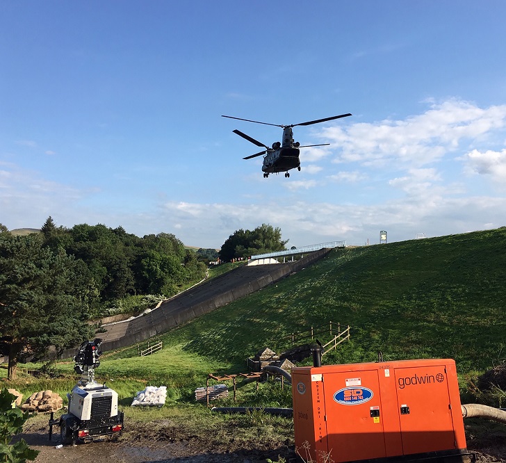 An RAF Chinook flies over one of SLD's hire units on site.