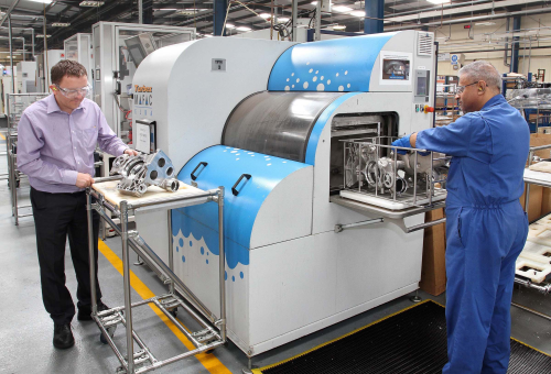 Aluminium pump housings entering the Turbex machine for cleaning. Mark McFall inspects a previously cleaned component.